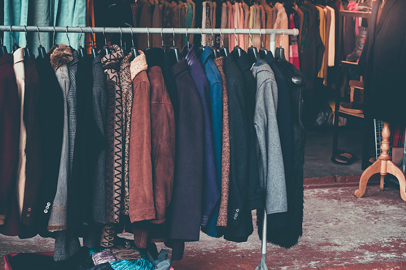 Kleiderstange mit Vintage Bekleidung in einem Second Hand Geschäft